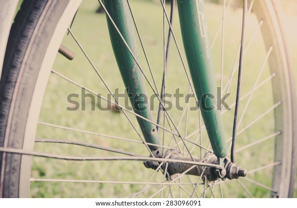 Detail of a Bicycle Handlebar Resting in\
vintage tone. Retro vintage bicycle at outdoor park with flowers on\
summer landscape\
background.