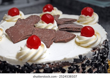 Detail of a black forest cake, sponge cake decorated with chantilly cream, grated bitter chocolate and cherries with squares of brown chocolate. - Powered by Shutterstock