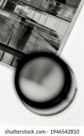 Detail of black and white 4x5 format film negative in protective transparent sleeve, next to a loupe on a light table.