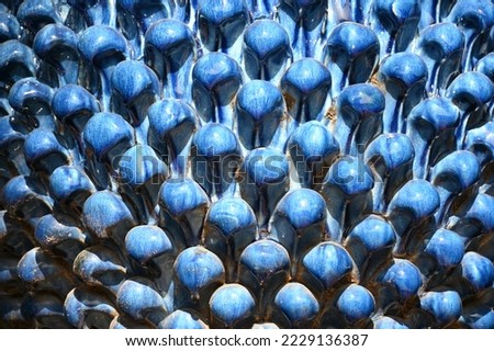 Detail of a blue ceramic pine cone as a garden decoration