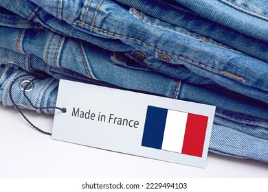 Detail of blue jeans, label and Made in France lettering. The concept of buying, selling, shopping and trendy modern clothes.