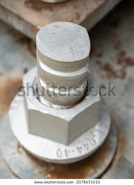 Detail of bolts.\
Steel plate based on anchor bolts on the concrete pillar urban\
support. PAinted steel\
bar\
\

