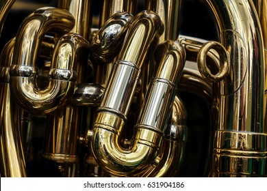 Detail Of The Brass Pipes Of A Tuba. Abstract Background Showing The Curves And Joints Of This Polished Brass Band Musical Instrument. 