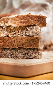 detail of brown bread, closeup of Sliced whole wheat food on a wooden chopping board (vertical picture)