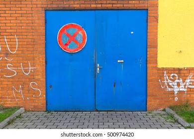 Detail of building with old blue door. Traffic sign of caution to not park in front of doors. - Shutterstock ID 500974420