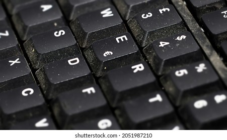 Detail of the buttons of a dusty black plastic european computer keyboard. Technology and computers. Dust and dirt - Shutterstock ID 2051987210