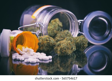 Detail of cannabis buds and prescriptions pills over reflective surface - medical marijuana dispensary concept