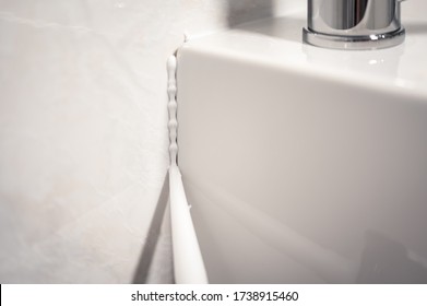 Detail Of A Cannula Applying Silicone To The Seal Of A Bathroom Sink