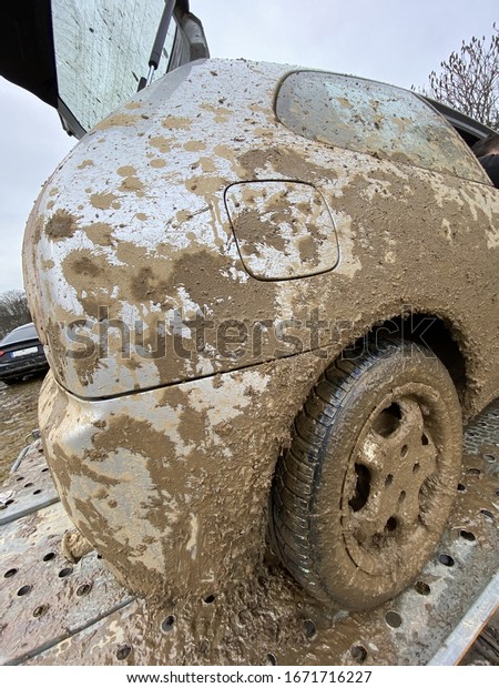 The detail of the car completely dirty by mud\
after the drag race on a field during winter. It needs complete\
cleaning of the exterior and interior.\
