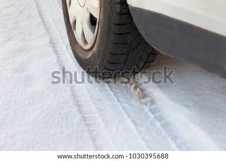 Detail of car wheel's tyre imprint on the snow. Winter tire imprint closeup shot. Pneumatic press into track in the snow. Day coach tyre impress on snow. Passenger carriage rubber ectype.