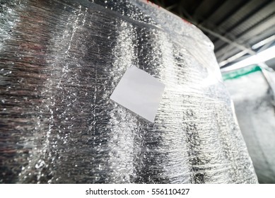 Detail Of A Cargo Container Packed In Shiny Foil Thermal Insulation. White Square Label.