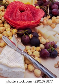 Detail Of A Cheese Board With Grape Nuts And A Flower With Salami Sausage