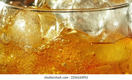 Detail of cider with ice cubes in glass. Extreme closeup, fresh beverages background.