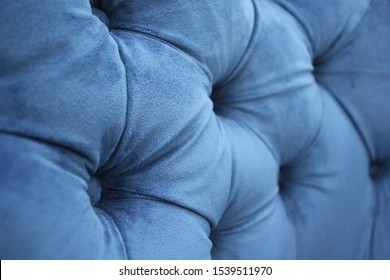 Detail of classic furniture, selective focus. Velour sofa close-up with part of the seat. Gray padded fabric upholstery of the sofa. Gray velvet with buttons on the upholstered furniture. - Powered by Shutterstock