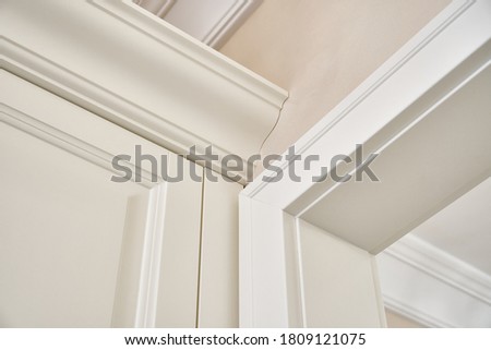 Detail of classic white wardrobe with seating and shelves in contemporary bright hallway. Classic furniture