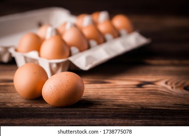 Detail close-up of chicken eggs in egg box on the old brown wooden background. - Powered by Shutterstock