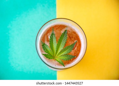 Detail of cold glass of beer with cannabis leaf, marijuana infused beverage concept