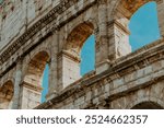 Detail of the Colosseum in Rome. Marble stone texture with beautiful Italy sky background. History of Rome and its gladiators.