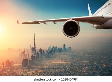 Detail of commercial jet plane flying above Dubai city. Modern and fastest mode of transportation, business life and luxury style of life