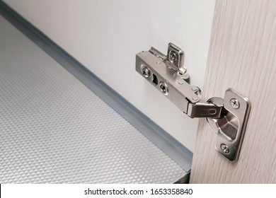 detail of concealed hinge on cabinet door, furniture fitting hardware for cupboard or wardrobe