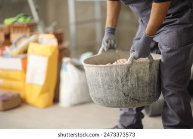 Detail of a construction worker lifting carrycot in a house under reform - Powered by Shutterstock