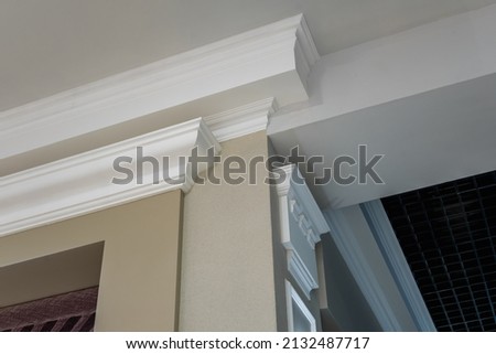 Detail of corner ceiling with intricate crown molding on column with spot light