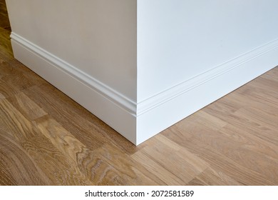 Detail of corner flooring with intricate crown molding and plinth. 