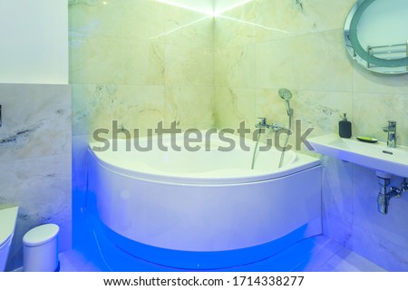 detail of a corner shower jacuzzi with wall mount shower attachment with neon light