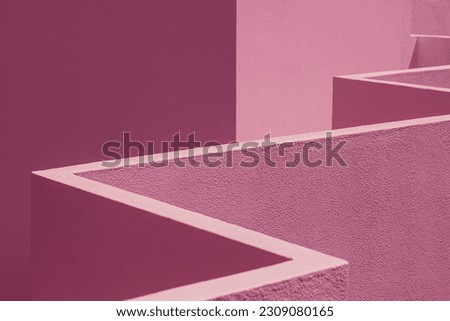 Detail of a corridor balcony made in cement. Pink composition of abstract geometric shapes, lines, angles and textures, creating a visually interesting and aesthetically appealing image. light shadow