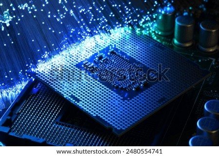 Detail of CPU on socket of a PC motherboard illuminated by a fiber optic lamp. Colorful background with high tech technology