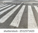 Detail of a crossing with pedestrian crossings and a stop sign for cars.