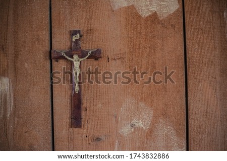 Detail of a Crucifix in an abandoned building on a wooden wall
