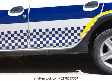 Detail Of The Decal With White And Blue Squares On The Lower Side Of A Spanish Local Police Car. Horizontal Image