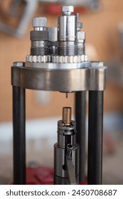 Detail of the decapping and resizing process of a 9mm case in the reloading press. To recover its original size and remove the worn primer and replace it with a new one