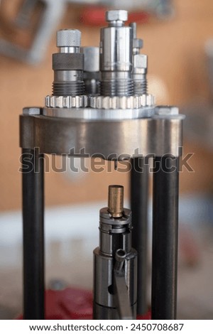 Detail of the decapping and resizing process of a 9mm case in the reloading press. To recover its original size and remove the worn primer and replace it with a new one