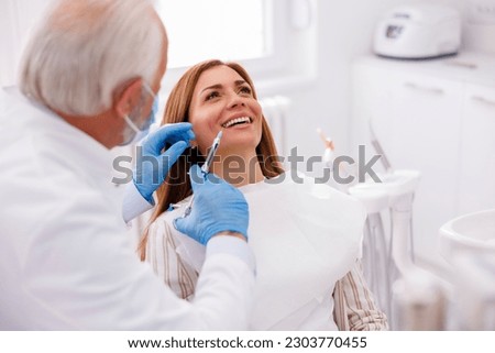 Detail of dentist applying local anesthetic to patient for numbing the pain before procedure; doctor applying lip fillers to female patient Imagine de stoc © 