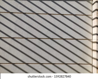 detail of diagonal shadow lines on textured white wall