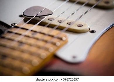 detail of an electric guitar with a pick on the strings with a small depth of field