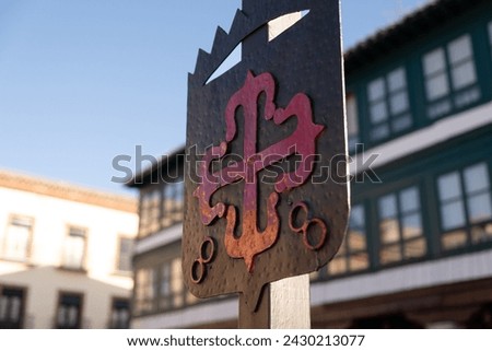 Detail of Emblem of the Order of Calatrava iluminated by the morning sun. red Greek cross with fleur-de-lis at its ends, in the Plaza Mayor of Almagro, Ciudad Real Traveling and sightseeing in Spain