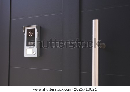 detail of an entrance door to a house with a doorbell with camera