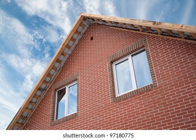 Detail Of The Facade Of A Brick House With A Roof And Windows