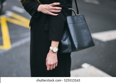 Detail Of A Fashionable Woman Wearing A Black Oversized Coat, A White And Golden Watch And A Black Trendy Handbag. Perfect Fall Fashion Outfit.

