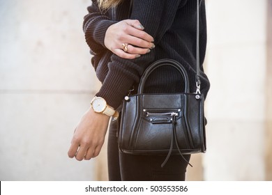 Detail Of A Fashionable Woman Wearing A Navy Blue Oversized Sweater, A White And Golden Watch And A Black Trendy Handbag, Black Jeans. Perfect Fall Fashion Outfit.

