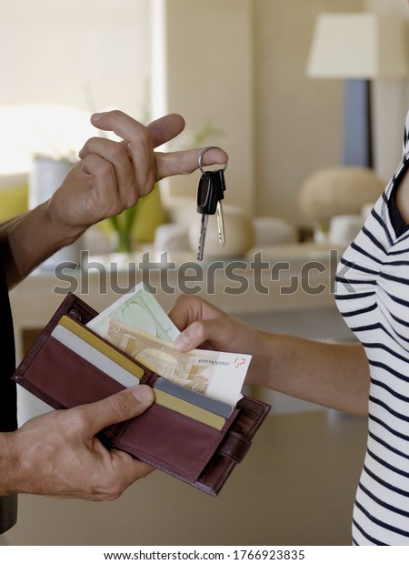 Detail of\
father giving daughter car keys and\
money