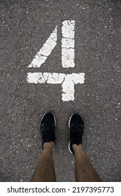 Detail Of Feet Above The Number Four On A Running Track