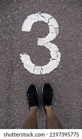 Detail Of Feet Above The Number Three On A Running Track