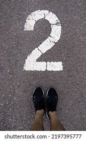 Detail Of Feet Above The Number Two On A Running Track