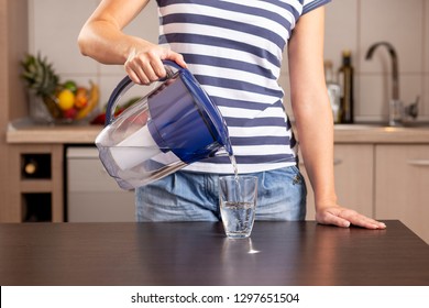 Detail Of Female Hands Holding A Filtered Water Pitcher And Pouring Filtered Water Into A Glass