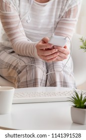 Detail Of Female Hands Holding A Smart Phone, Surfing The Net And Scrolling. Focus On The Phone