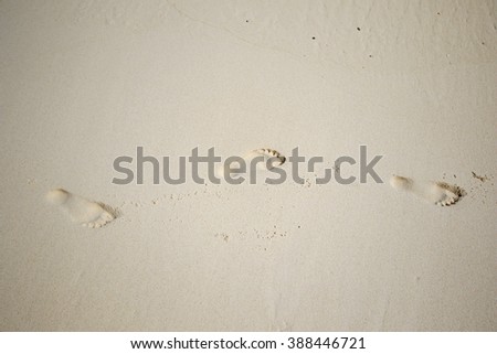 Detail of footprints on the sand and sea